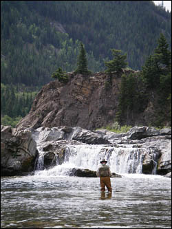 angler-choosing-fly-below-waterfall.jpg